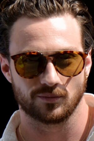 aaron taylor johnson attore inglese con camicia bianca barba e occhiali da sole