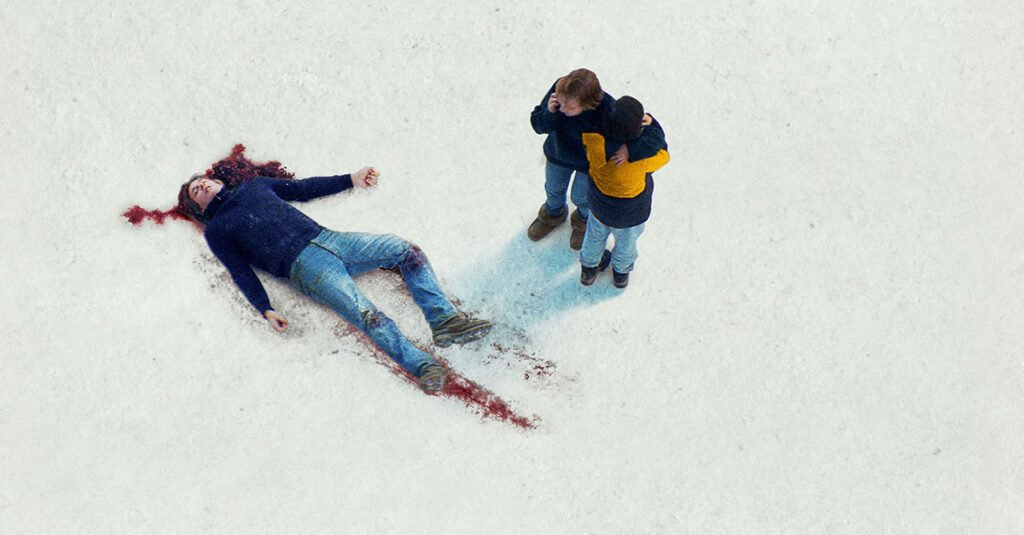 anatomia di una caduta film dettaglio locandina con uomo a terra nella neve e madre e figlio abbracciati
