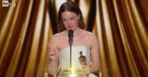 notte degli oscar 2024 emma stone con premio miglior attrice in vestito bianco punta il dito contro ryan gosling in platea